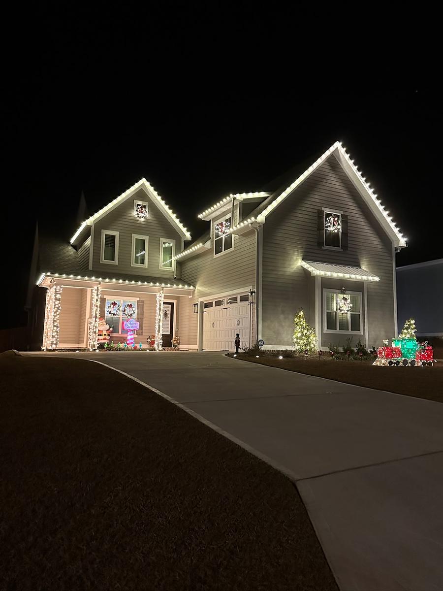 Two-story home with warm white roofline and gable lights